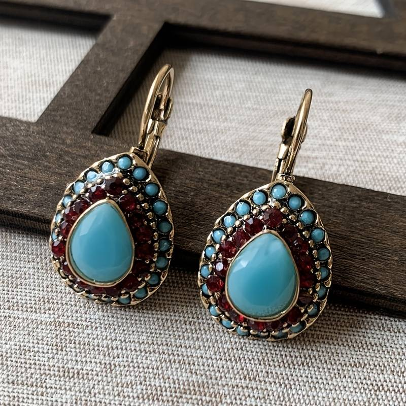 Goldene Ohrringe mit blauem Opal-Tropfen
